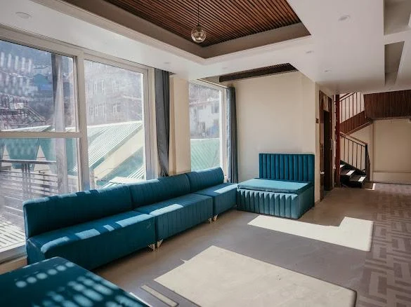 Lounge with teal sofas and big windows